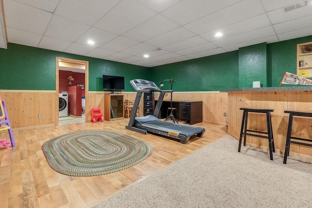 431 Ridgeway Dr, Brillion, WI 54110 - exercise area featuring washer / dryer, a wainscoted wall, a paneled ceiling, wood walls, and wood finished floors
