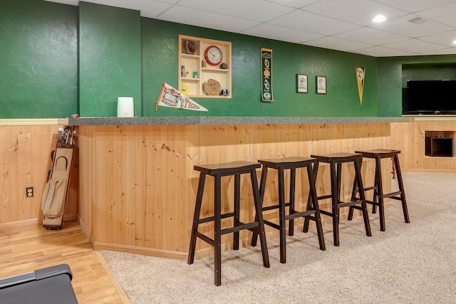 431 Ridgeway Dr, Brillion, WI 54110 - indoor bar with wooden walls, a textured wall, a paneled ceiling, wood finished floors, and built in features