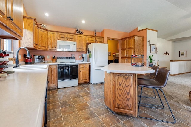 431 Ridgeway Dr, Brillion, WI 54110 - kitchen featuring white appliances, lofted ceiling, light countertops, a kitchen bar, and brown cabinetry