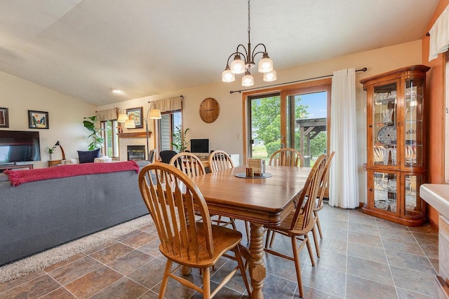 431 Ridgeway Dr, Brillion, WI 54110 - dining space with lofted ceiling, stone tile flooring, a fireplace, and a chandelier