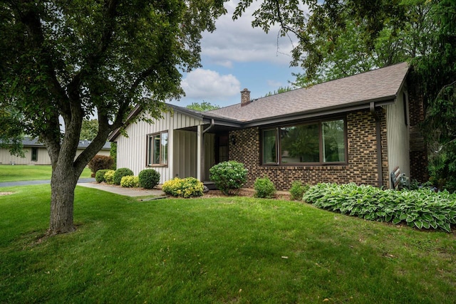 5325 Linden Cir, Racine, WI 53406 - view of front of home with a chimney, a front lawn, brick siding, and board and batten siding