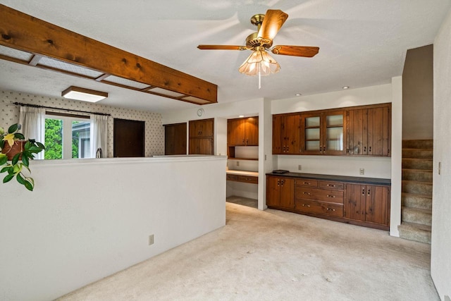 5325 Linden Cir, Racine, WI 53406 - kitchen with light carpet, glass insert cabinets, a ceiling fan, and dark countertops