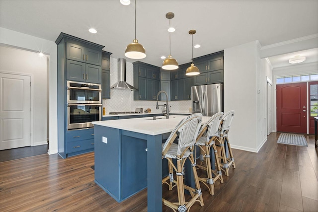 7949 W Oakwood Way, Franklin, WI 53132 - kitchen with wall chimney range hood, appliances with stainless steel finishes, light countertops, decorative backsplash, and dark wood-style floors
