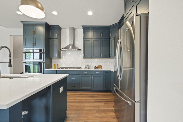 7949 W Oakwood Way, Franklin, WI 53132 - kitchen with stainless steel appliances, wall chimney exhaust hood, dark wood finished floors, decorative backsplash, and light countertops