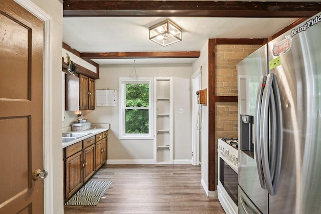 3352 S Adams Ave, Milwaukee, WI 53207 - kitchen featuring stainless steel fridge, white gas range oven, light wood-style floors, brown cabinetry, and light countertops