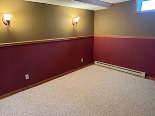 1064 Sunny Ridge Cir, Nekoosa, WI 54457 - below grade area featuring baseboard heating, a drop ceiling, and carpet flooring