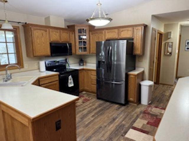 1064 Sunny Ridge Cir, Nekoosa, WI 54457 - kitchen with black appliances, dark wood-style flooring, light countertops, glass insert cabinets, and brown cabinets