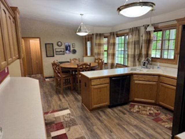 1064 Sunny Ridge Cir, Nekoosa, WI 54457 - kitchen featuring dishwasher, dark wood finished floors, a peninsula, light countertops, and pendant lighting