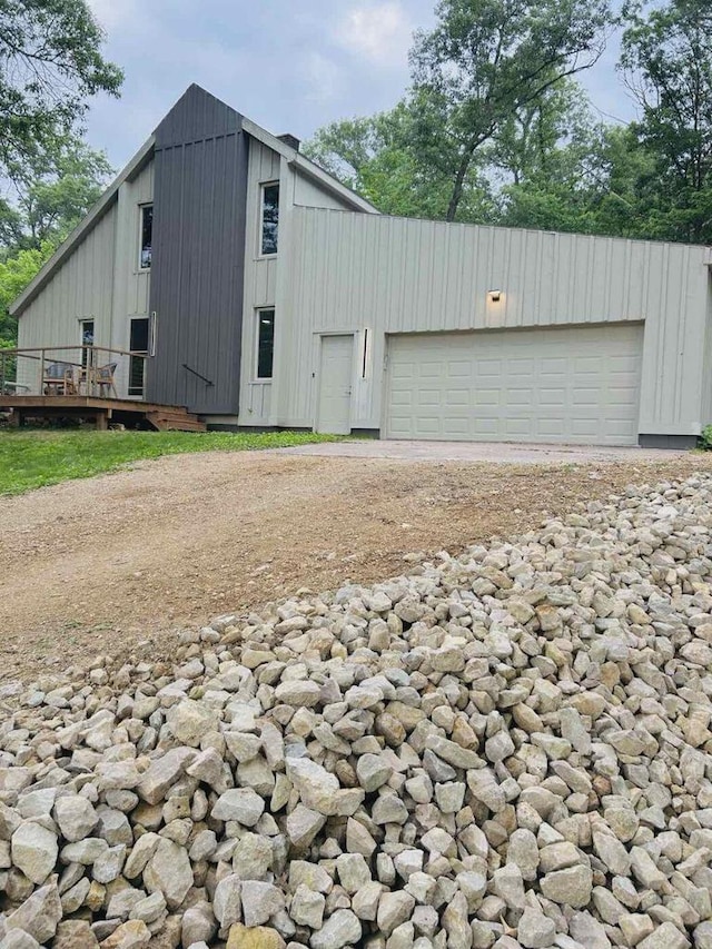 5869 Country Club Rd, Houston, MN 55943 - view of front of house with board and batten siding, a wooden deck, and dirt driveway