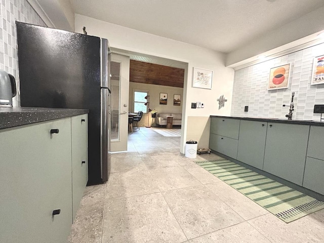 5869 Country Club Rd, Houston, MN 55943 - kitchen with decorative backsplash, freestanding refrigerator, and dark countertops