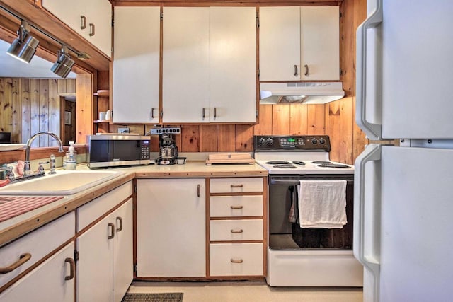1119 Gross Rd, Woodruff, WI 54568 - kitchen featuring white appliances, under cabinet range hood, wooden walls, light countertops, and white cabinets
