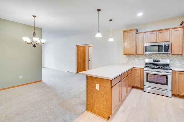 7942 Williamsburg Ct Unit 101, Bristol, WI 53104 - kitchen with appliances with stainless steel finishes, a peninsula, backsplash, a chandelier, and light countertops