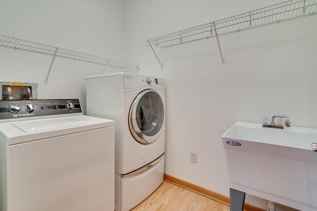 7942 Williamsburg Ct Unit 101, Bristol, WI 53104 - laundry room with washer and clothes dryer and light wood-style flooring
