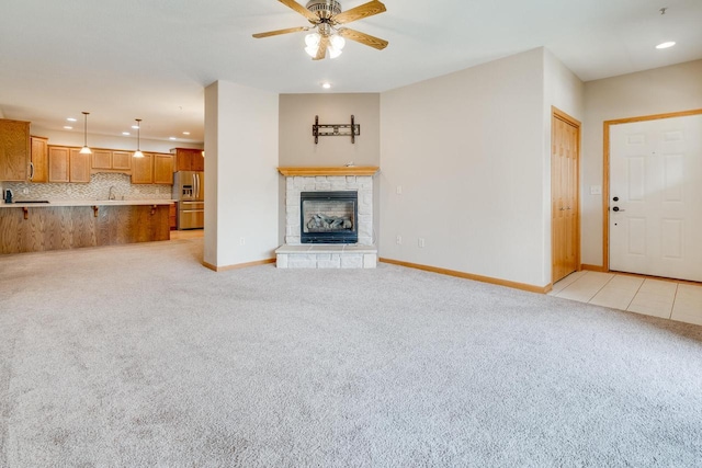 7942 Williamsburg Ct Unit 101, Bristol, WI 53104 - unfurnished living room featuring recessed lighting, light colored carpet, ceiling fan, and a fireplace with raised hearth