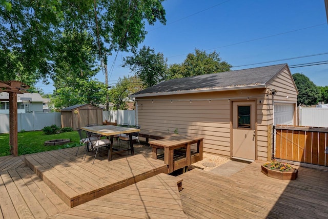 3202 34th St, South Street, La Crosse, WI 54601 - wooden terrace featuring outdoor dining area, a fenced backyard, a storage shed, and a fire pit