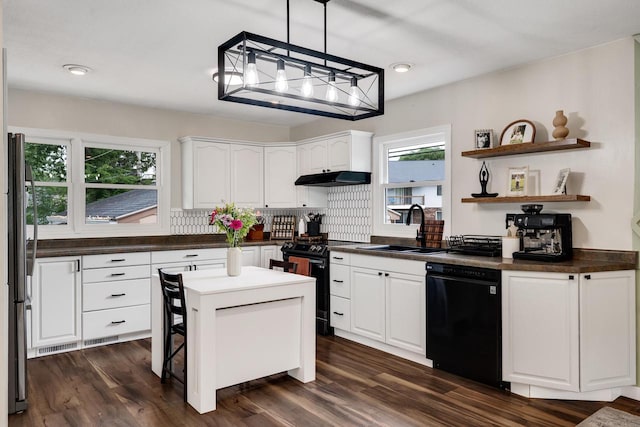 3202 34th St, South Street, La Crosse, WI 54601 - kitchen with black appliances, under cabinet range hood, dark countertops, decorative backsplash, and white cabinets