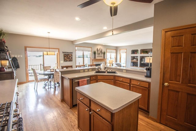 120 Wind Sail Ct, Random Lake, WI 53075 - kitchen with stainless steel dishwasher, brown cabinets, light countertops, a ceiling fan, and light wood-style floors