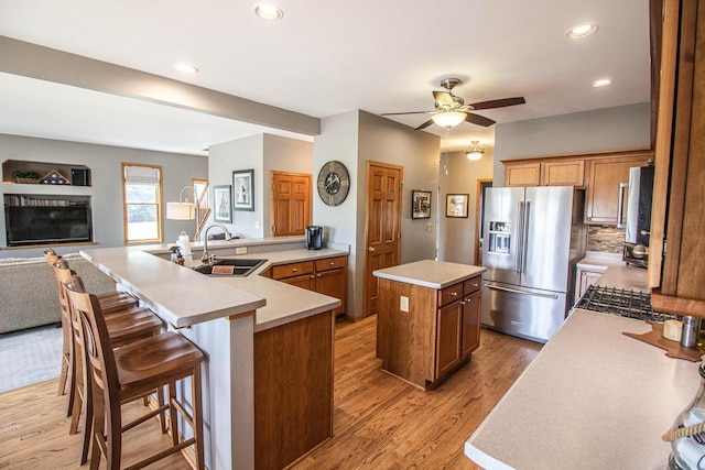 120 Wind Sail Ct, Random Lake, WI 53075 - kitchen featuring stainless steel fridge with ice dispenser, a large island, light wood-style flooring, ceiling fan, and light countertops