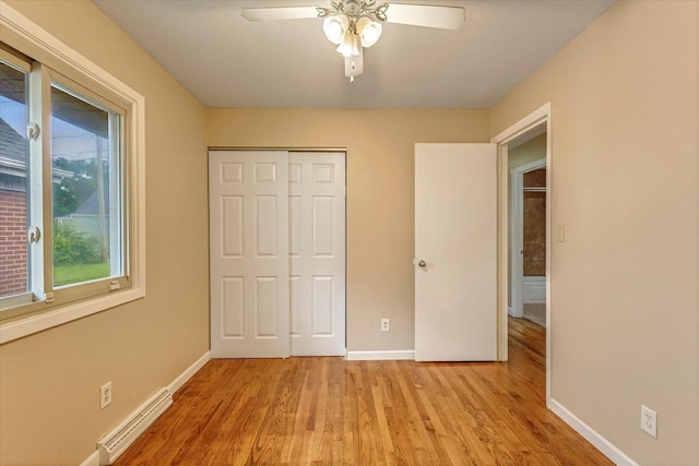 3918 W Hampton Ave, Milwaukee, WI 53209 - unfurnished bedroom with a baseboard radiator, light wood-style flooring, a closet, and ceiling fan