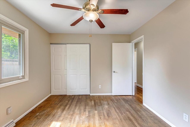3918 W Hampton Ave, Milwaukee, WI 53209 - unfurnished bedroom featuring a baseboard heating unit, wood finished floors, a closet, and ceiling fan
