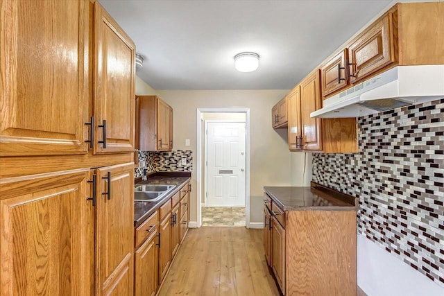 3918 W Hampton Ave, Milwaukee, WI 53209 - kitchen featuring dark countertops, backsplash, under cabinet range hood, and light wood finished floors