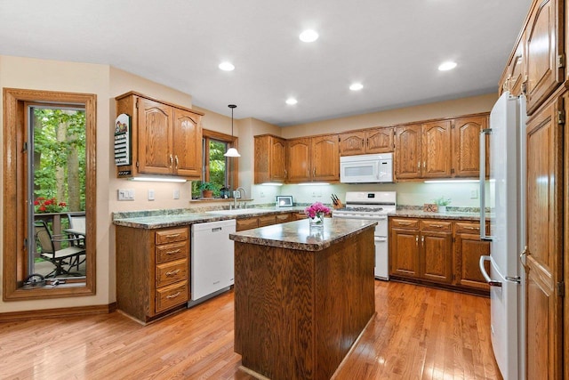 2510 Hillside Heights Dr, Green Bay, WI 54311 - kitchen featuring white appliances, brown cabinets, light wood-style floors, a center island, and recessed lighting
