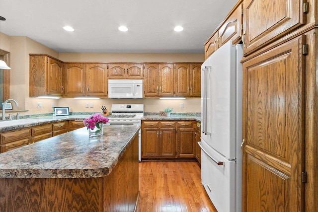 2510 Hillside Heights Dr, Green Bay, WI 54311 - kitchen with white appliances, brown cabinets, light wood-style floors, recessed lighting, and a kitchen island