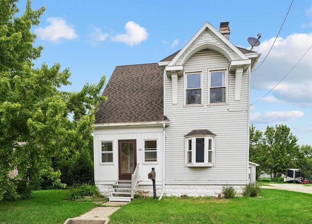 136 Oak St, Brillion, WI 54110 - view of front facade with a front lawn, a shingled roof, a chimney, and entry steps