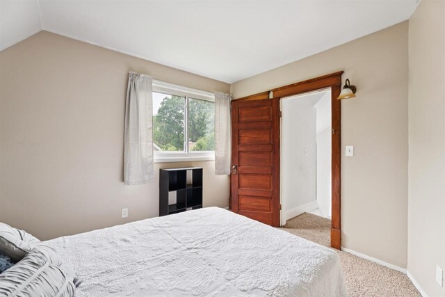 136 Oak St, Brillion, WI 54110 - carpeted bedroom with baseboards and vaulted ceiling