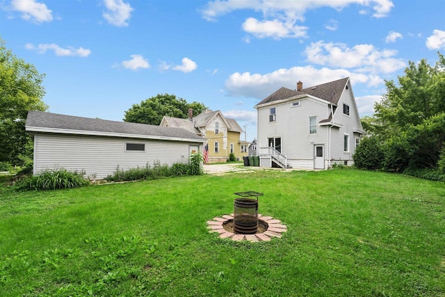 136 Oak St, Brillion, WI 54110 - back of property with an outdoor fire pit, a yard, and a chimney