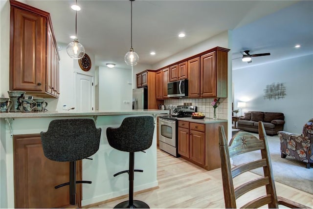1403 Elm Ave, Menomonie, WI 54751 - kitchen with stainless steel appliances, a breakfast bar, tasteful backsplash, light countertops, and a peninsula