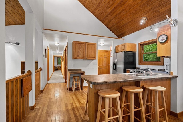 N12757 Rivers Meet Dr, Athelstane, WI 54104 - kitchen with stainless steel fridge with ice dispenser, wooden ceiling, vaulted ceiling, light wood-style floors, and a breakfast bar area