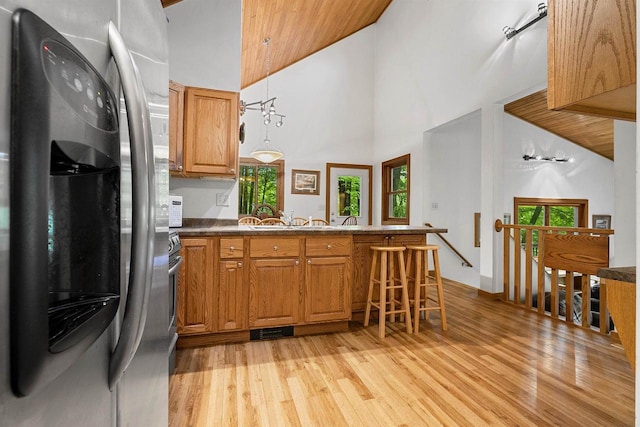 N12757 Rivers Meet Dr, Athelstane, WI 54104 - kitchen featuring freestanding refrigerator, high vaulted ceiling, light wood finished floors, a peninsula, and brown cabinetry