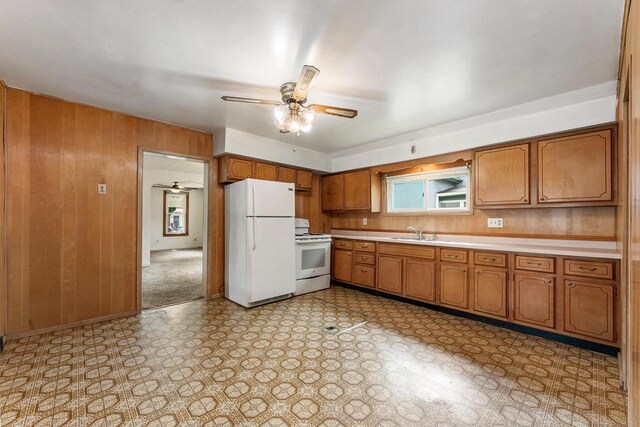 1647 Loomis St, La Crosse, WI 54603 - kitchen featuring white appliances, brown cabinetry, ceiling fan, light countertops, and wood walls