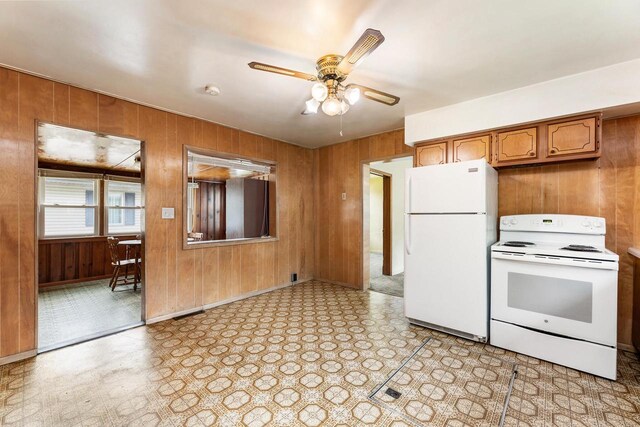 1647 Loomis St, La Crosse, WI 54603 - kitchen featuring white appliances, wooden walls, ceiling fan, brown cabinets, and light floors
