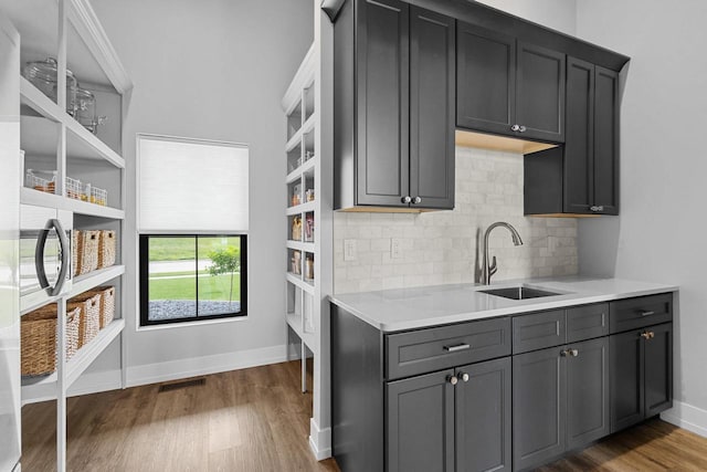 7205 N Trinity Ct, Appleton, WI 54913 - kitchen featuring light countertops, dark wood-type flooring, tasteful backsplash, open shelves, and gray cabinetry