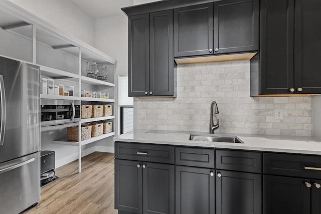 7205 N Trinity Ct, Appleton, WI 54913 - kitchen featuring appliances with stainless steel finishes, light countertops, backsplash, and light wood-style flooring