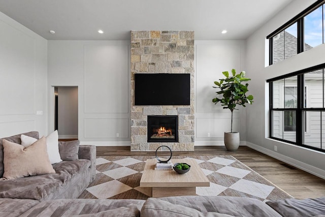 7205 N Trinity Ct, Appleton, WI 54913 - living room featuring a stone fireplace, wood finished floors, and recessed lighting
