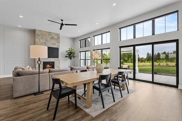 7205 N Trinity Ct, Appleton, WI 54913 - dining space with a fireplace, a ceiling fan, wood finished floors, recessed lighting, and a towering ceiling