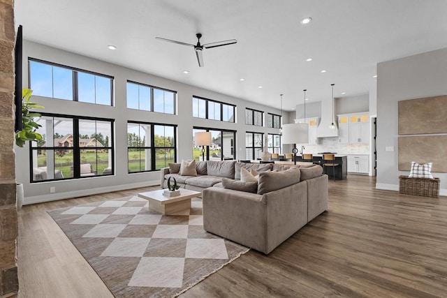 7205 N Trinity Ct, Appleton, WI 54913 - living room featuring recessed lighting, ceiling fan, wood finished floors, and a towering ceiling