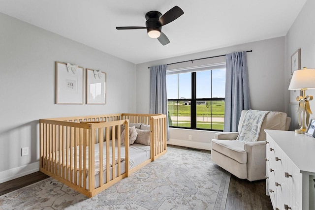 7205 N Trinity Ct, Appleton, WI 54913 - bedroom featuring dark wood-style flooring, a nursery area, and ceiling fan