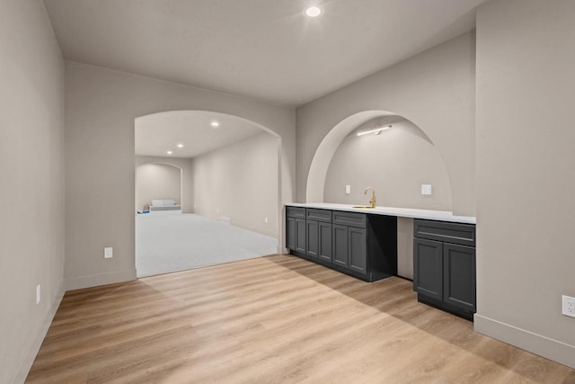 7205 N Trinity Ct, Appleton, WI 54913 - bar area featuring light wood-style floors, arched walkways, and recessed lighting