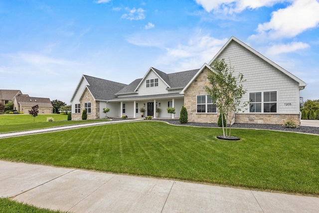 7205 N Trinity Ct, Appleton, WI 54913 - view of front of house with stone siding, a front lawn, a porch, and a shingled roof