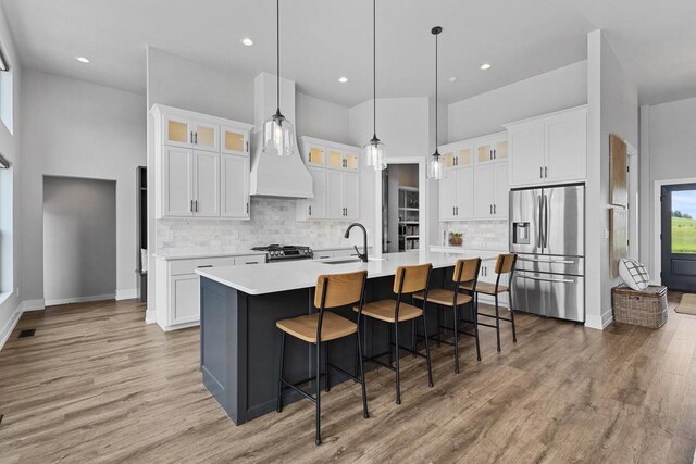 7205 N Trinity Ct, Appleton, WI 54913 - kitchen with stainless steel appliances, light wood-type flooring, a large island with sink, light countertops, and recessed lighting