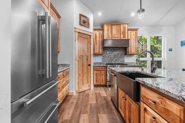 3838 Bear Lake Ln, Laona, WI 54541 - kitchen with stainless steel appliances, light wood-style floors, tasteful backsplash, light stone counters, and pendant lighting