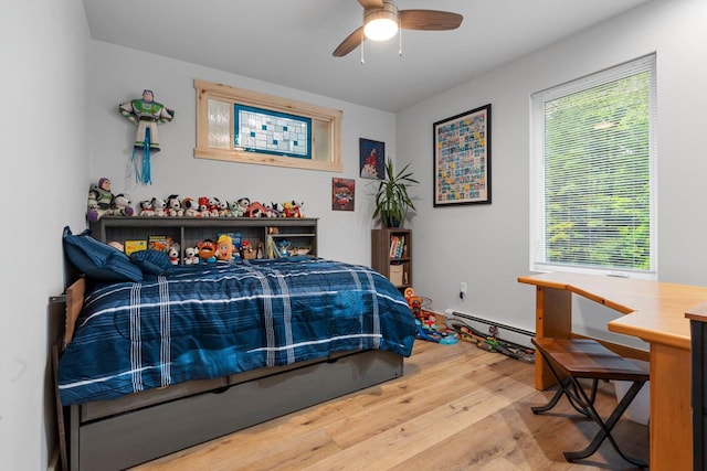 3838 Bear Lake Ln, Laona, WI 54541 - bedroom featuring baseboard heating, wood finished floors, and a ceiling fan