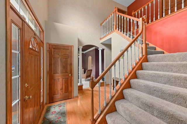 20750 Chadwick Ln, Brookfield, WI 53045 - entrance foyer featuring arched walkways, a high ceiling, wood finished floors, stairs, and ornate columns
