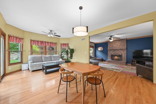 20750 Chadwick Ln, Brookfield, WI 53045 - dining area featuring ceiling fan, light wood-style floors, a fireplace, and plenty of natural light