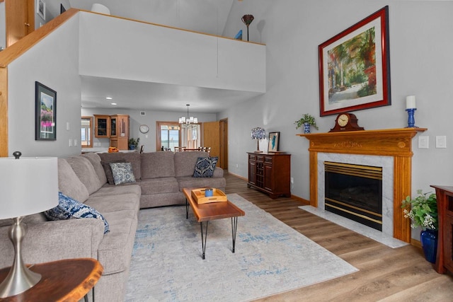 N7861 Lakeshore Dr, Fond Du Lac, WI 54937 - living area featuring wood finished floors, a chandelier, a premium fireplace, a high ceiling, and recessed lighting