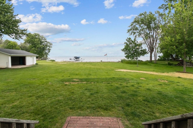 N7861 Lakeshore Dr, Fond Du Lac, WI 54937 - view of grassy yard featuring a water view, an outdoor structure, and a garage